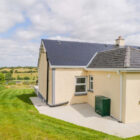 Cream painted bungalow with grey slate roof set in Irish countryside