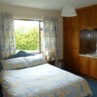 Bedroom with built in pine wardrobes and double bed with lemon and blue patterned bedding