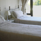 Bedroom with two single beds with metal framed headboard and white bed linen