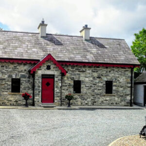 Stone built cottage with grey slate roof and red painted door