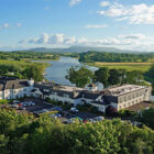 White hotel beside lough surrounded by trees