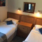 Bedroom with two single beds either side of pine cabinet