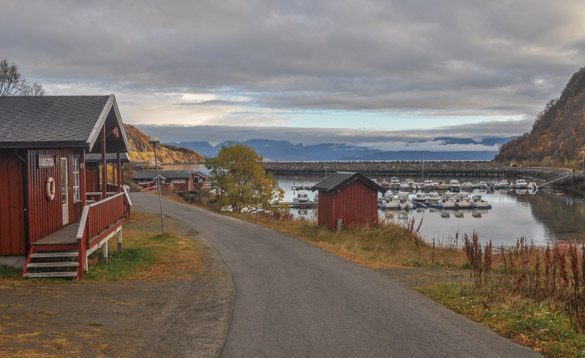 Norway-fishing-holidays-Skjervoy(1) Red painted wooden cabin at the top of a hill with views across a fjord and harbour