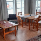 Living room with pine table and three chairs beside two windows