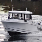 White angling boat with cabin on fjord in Norway
