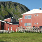 Red painted buildings with white roof in front of a mountain