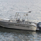 Aluminium fishing boat moored against a jetty