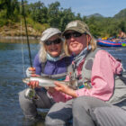 Two ladies holding a rainbow trout caught in Alaska