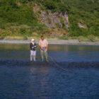 Man and lady fly fishing in a river in Alaska