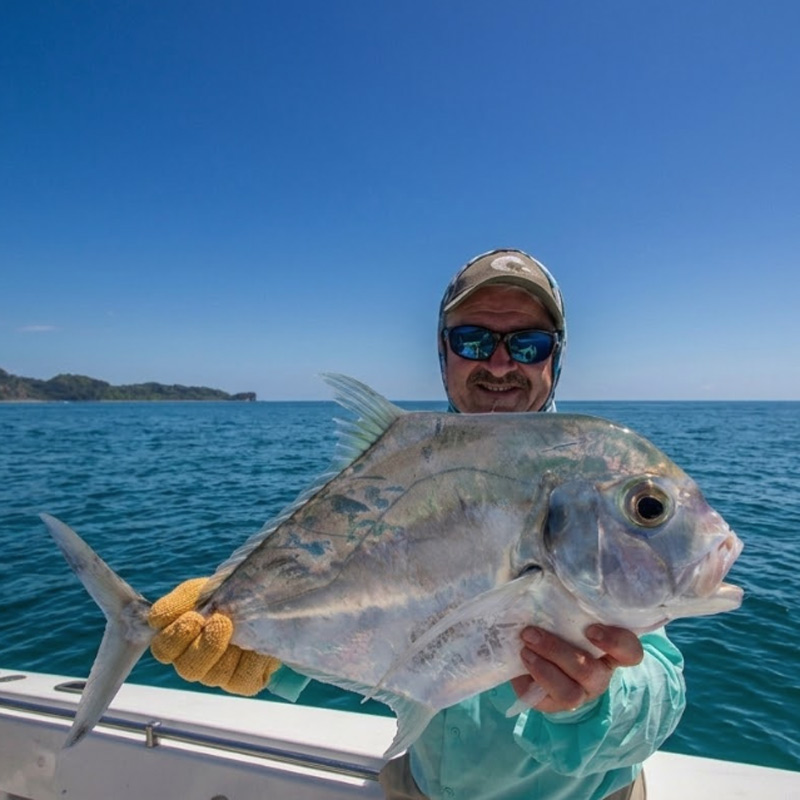 Angler holding a Diamond Trevally fish
