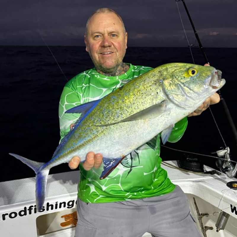 Angler holding a bluefin trevally fish