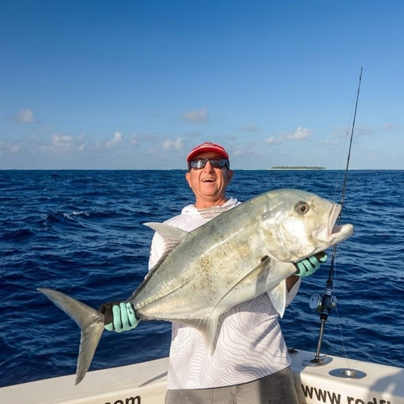 Angler holding a giant trevally fish