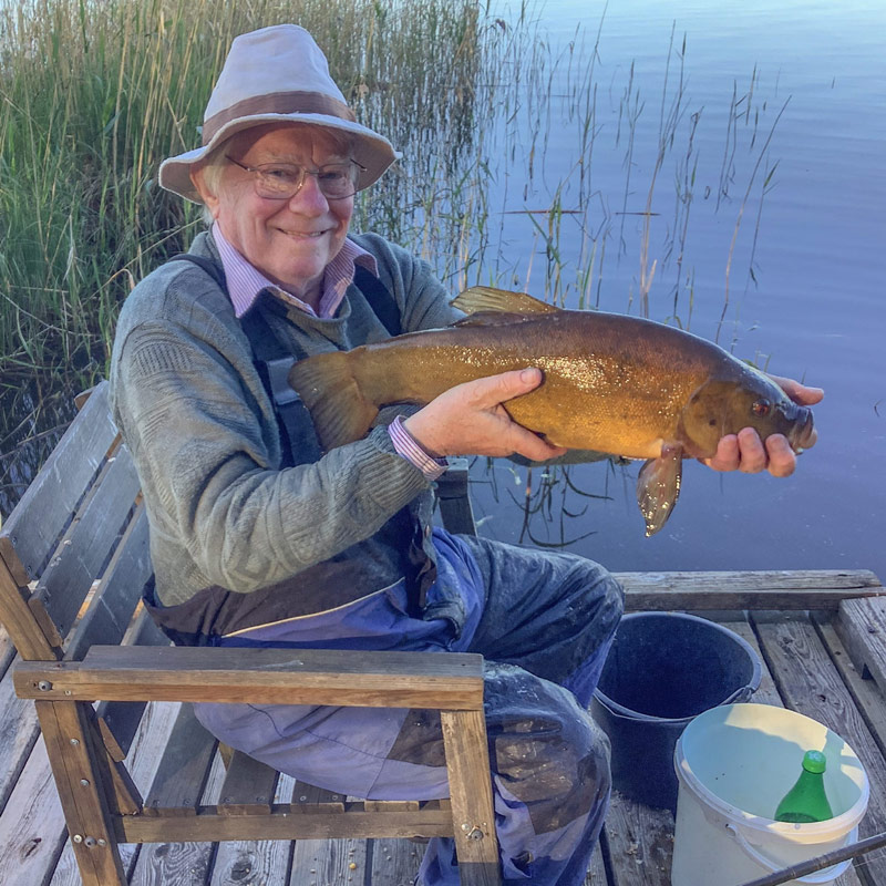 Angler holding a tench caught in Sweden