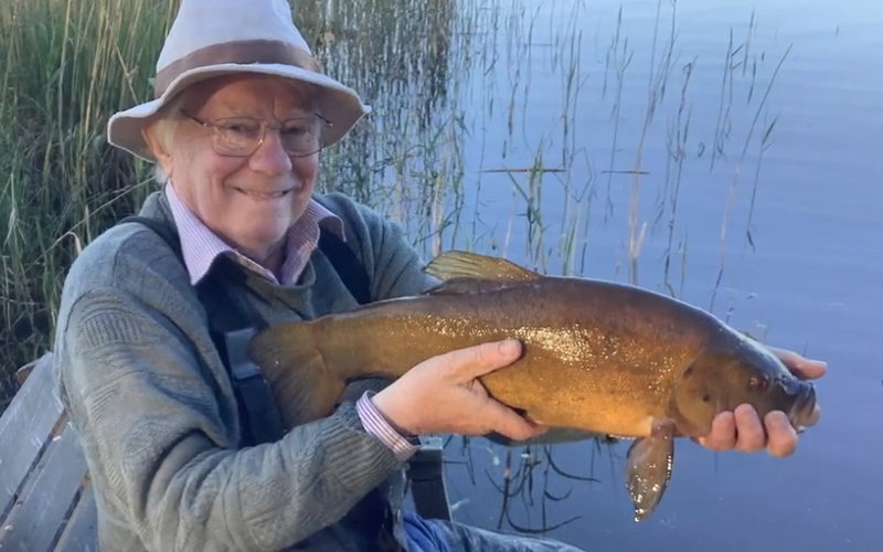 Angler holding a tench fish