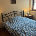 Double bed with a blue and white geometric duvet and matching bedside lamps.
