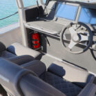 Modern boat helm console with steering wheel, navigation screens, controls, and cushioned seats.